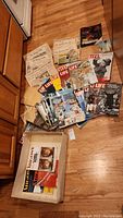 Overview of collection featuring Life magazines spread on floor with newspaper clippings and other magazines visible