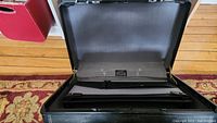 Photo of the opened lockable briefcase showing the interior with items inside.