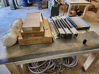 Photo showing a table with multiple Blum Legrabox drawer runners laid out, along with several Legrabox hardware boxes labeled with quantities and sizes.