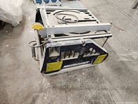 Mastercraft table saw top-down view showing tabletop surface, circular saw blade, yellow blade guard, and hand crank adjustment mechanism.