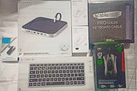 Top view showing all items in lot including Satechi stand hub, wireless transmitter & receiver, CableMod pro coiled keyboard cable, Razer DeathAdder V2 Pro mouse, and Satechi keyboard