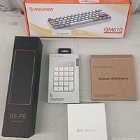 Five computer accessories laid out on a table, showing all boxed items including keyboard and peripherals