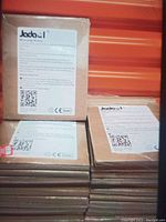 Box packaging with Jadaol warranty policy label visible, stacked boxes of cables