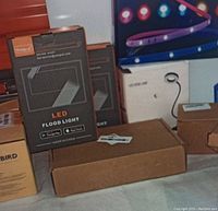 LED flood lights in black packaging with branding YangcsL, showing front of flood light and app compatibility logos