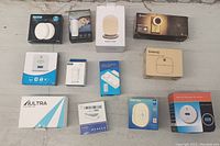 Photo showing all 12 items from above, including boxes and loose devices on tabletop.