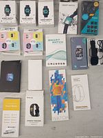 Full overhead image showing all boxed smart watches and fitness trackers arranged on a surface