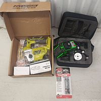 Cordless jigsaw in box, laser level in foam case, and JB Weld SteelStik adhesive package all visible together on floor.