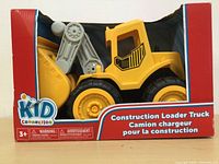 Image of the front of the box showing the yellow loader truck inside clear window packaging