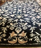 Full view of the rectangular rug showing floral pattern on dark background.