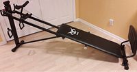 Black Voit Body Gym incline exercise bench with foldable frame on wooden floor.