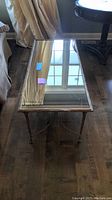 Rectangular mirrored coffee table viewed from above showing the entire top surface, reflecting window and showing some scratches.