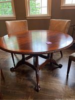 Full view of round dining table with chairs removed showing rope twist edge and pedestal base