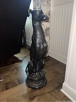 Angled front view of full statue on hardwood floor showing overall form and proportions