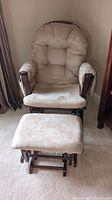 Front view of beige glider chair with matching ottoman, showing padded microfiber upholstery and wood look frame.