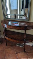 Full front view of demi-lune table beneath mirror