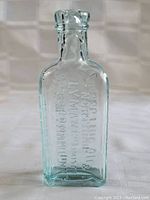 Front and side view of the aqua medicine bottle showing embossed text and condition.