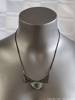 Necklace displayed on a bust form showing the Eilat stone centerpiece and silver chain.