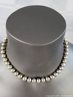 Front view of sterling silver ball necklace displayed on a black bust