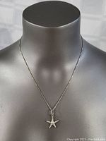 Front view of necklace worn on a black mannequin bust showing chain length and pendant placement.