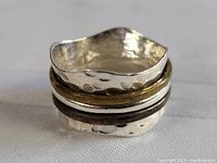 Close-up photo of sterling silver worry ring showing hammered texture and mixed metal tones