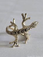 Close-up image of sterling silver gecko-shaped ring showing detailed design and black accents