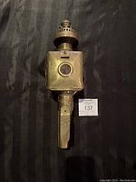 Top front view of brass carriage lamp showing oval front with red reflector.