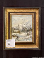 Framed winter landscape painting of a snowy cabin scene by John Strandberg.