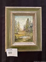Full view of the framed original painting showing a natural landscape with trees, water, and a meadow under a soft sky.