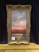 Full view of the framed painting showing lighthouse and sunset scene