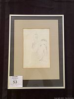 Framed pencil sketch of a seated figure with beige mat and light frame.