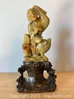 Front view of the carved figure on toad mounted on stone base