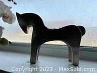 Side angle view of the silver tone metal Dala horse, showing sleek minimalist profile and standing on four legs.
