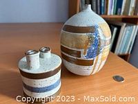 Close view of the smaller squat stoneware vase with dual narrow necks and horizontal multi-colored bands