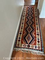 Full view of runner laid on hardwood floor showing overall length, pattern and color.