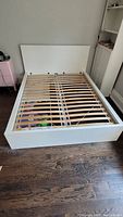 Front angle view of assembled white MALM bed frame showing slatted base