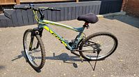 Full side view of grey and neon yellow CCM mountain bike with 26 inch wheels, showing frame, tires, handlebar and saddle.
