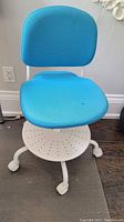 Full view of the blue IKEA VIMUND child's desk chair showing seat, backrest, base and wheels.