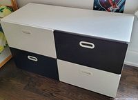 Closed view of the black and white cupboard showing 4 drawers in alternating colors.