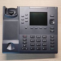 Front view of Mitel 6867i IP Telephone showing screen, buttons, keypad, and handset cradle.