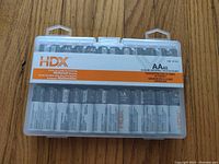 Front view of HDX branded clear plastic battery storage case holding 48 AA alkaline batteries.