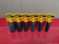 Six Dewalt deep impact metric sockets from 12mm to 24mm displayed upright with packaging tags.