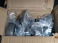 Four 3-inch casters in plastic packaging inside a box showing the set and individual items.