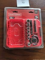 Photo of the front of the sealed Craftsman 26 piece palm ratchet set showing tools in the red hard case.