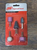 Front view of 5-piece Ingersoll Rand grinding stones set in blister pack, shows all pieces and original packaging.