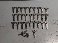 28 new slow close cabinet hinges laid out on a surface, shown in rows with some separated components.