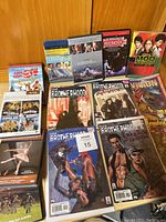 Photo showing four comics from The Brotherhood series and an assortment of DVDs including The Nutcracker, The Mod Squad, A Passage to India, and more comedy DVDs.