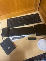 Top view of keyboard, laptop dock, charger, external floppy and DVD drives on desk