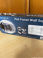 Box displaying Monoprice branded flat panel TV wall support, mentioning adjustable bracket for large plasma and LCD screens, weight capacity up to 165 pounds.