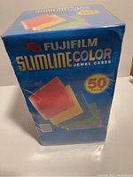 Box of Fujifilm Slimline Color Jewel Cases, sealed 50 pack shown from side with branding and colors