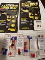 Two pistol grip adjustable spray heads in original packaging and five sets of replacement nozzles in plastic cases.